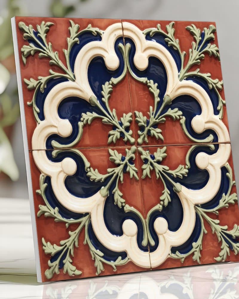 Ornate square tile with a red, blue, and cream floral design.