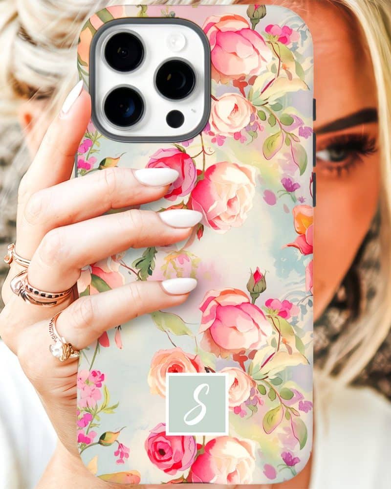 Woman holding iPhone case with floral design and monogram.