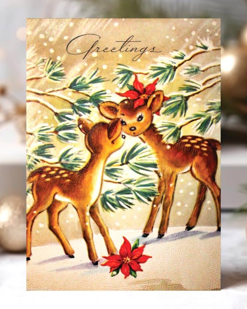 Vintage Christmas card featuring two deer nuzzling under a snowy pine bough.