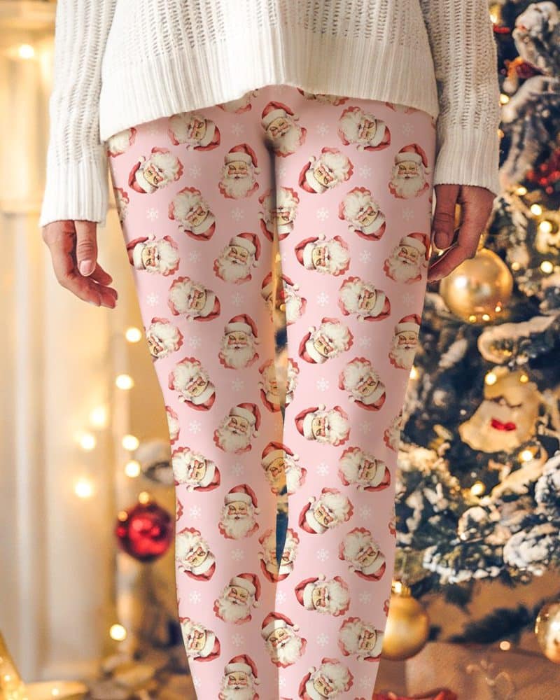 Pink leggings featuring a repeating pattern of vintage Santa Claus faces.