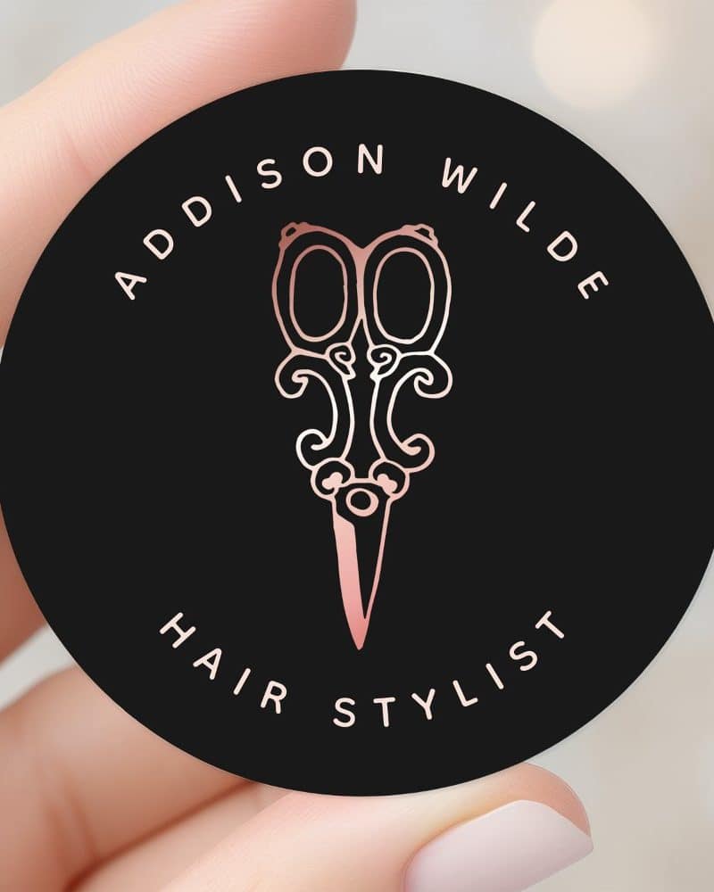 Rose gold scissors on a black circle, reading Addison Wilde Hair Stylist.