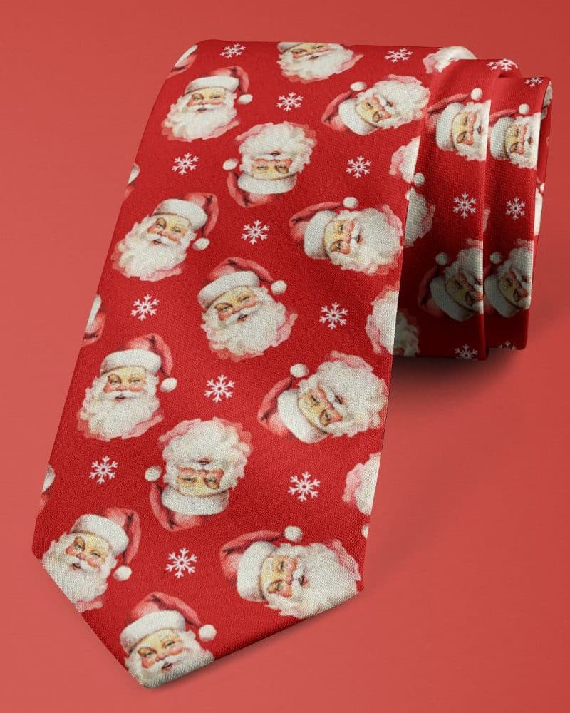Red necktie with a repeating pattern of Santa Claus faces and snowflakes.