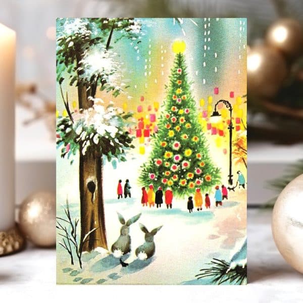 A Snowy Winter Scene With A Large Decorated Christmas Tree Surrounded By People, Two Rabbits In The Foreground, And A Snow-Covered Park.
