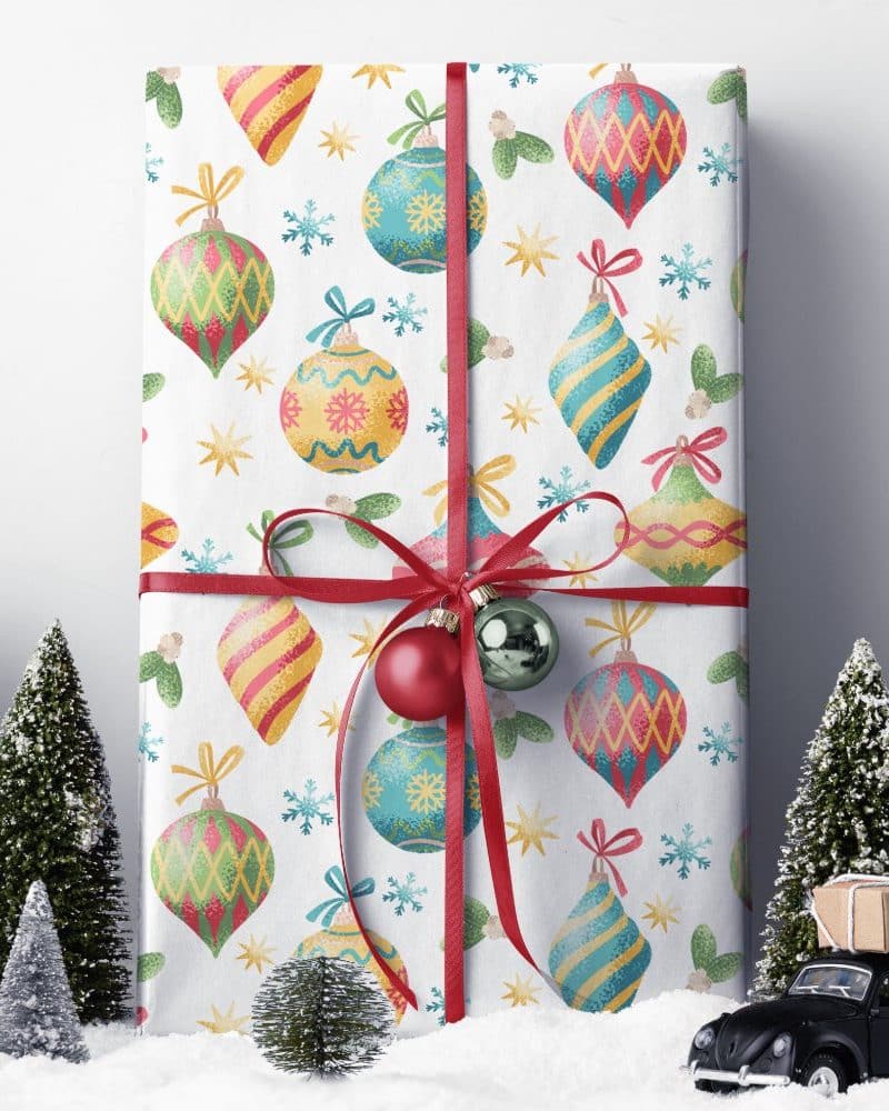 Christmas gift wrapped in paper with a pattern of colorful ornaments.