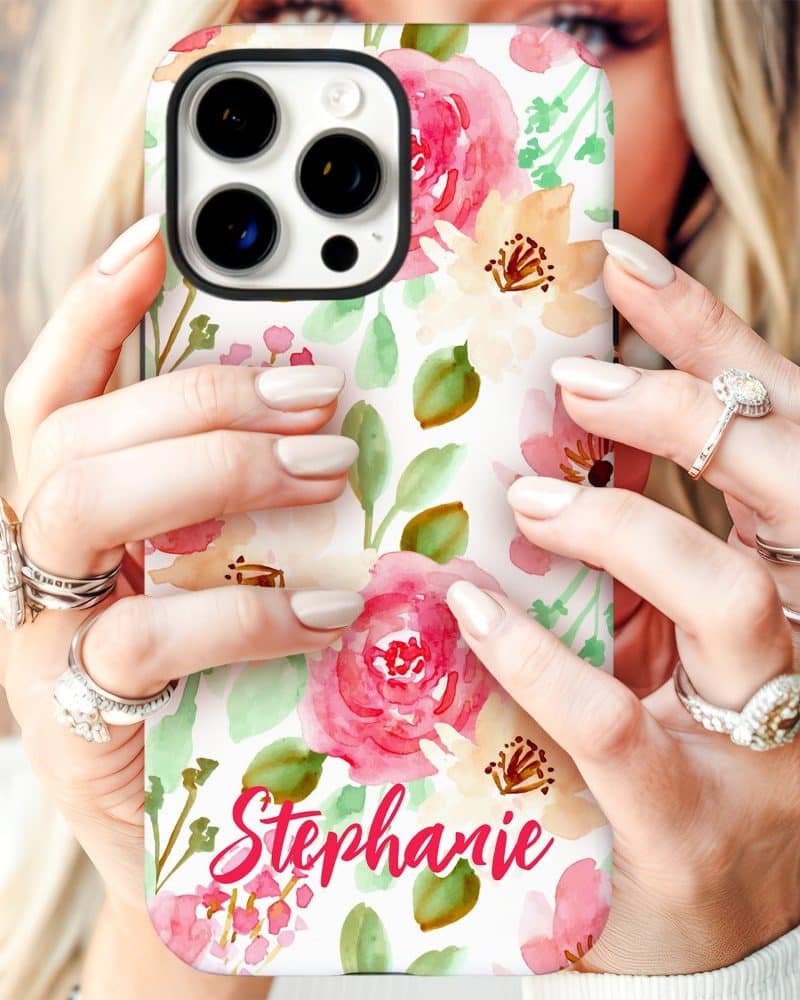 A woman's hands hold a phone case with a watercolor floral design and the name Stephanie.