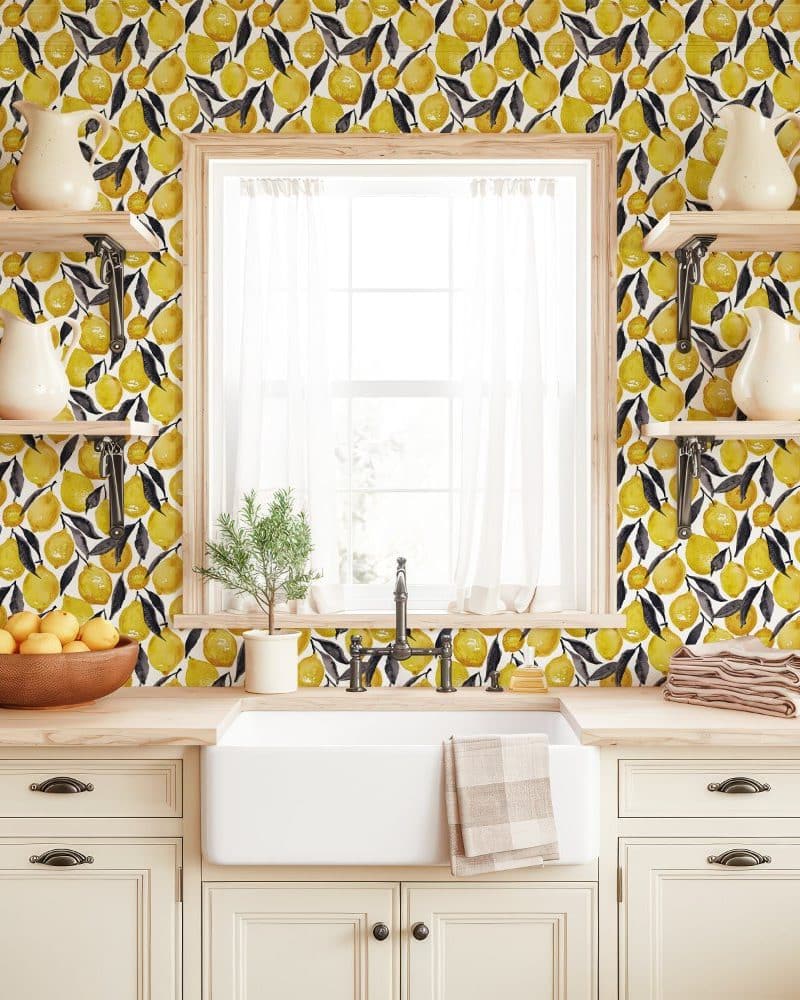 Kitchen with lemon wallpaper and farmhouse style sink and cabinets.