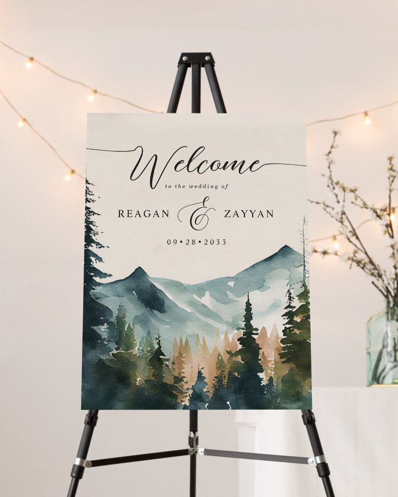 Wedding welcome sign with watercolor mountains and forest scene; Reagan and Zayyan's wedding date is September 28, 2033.