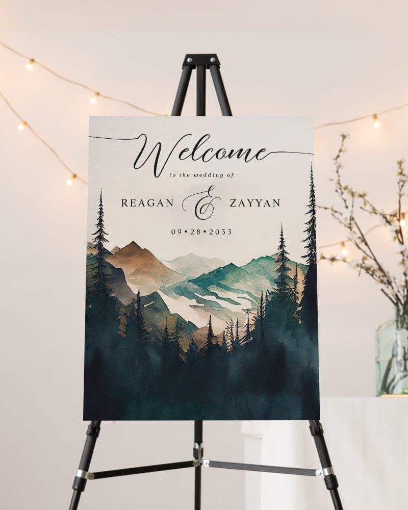 Wedding welcome sign with watercolor mountains and forest scene, names Reagan and Zayyan, and date September 28, 2033.