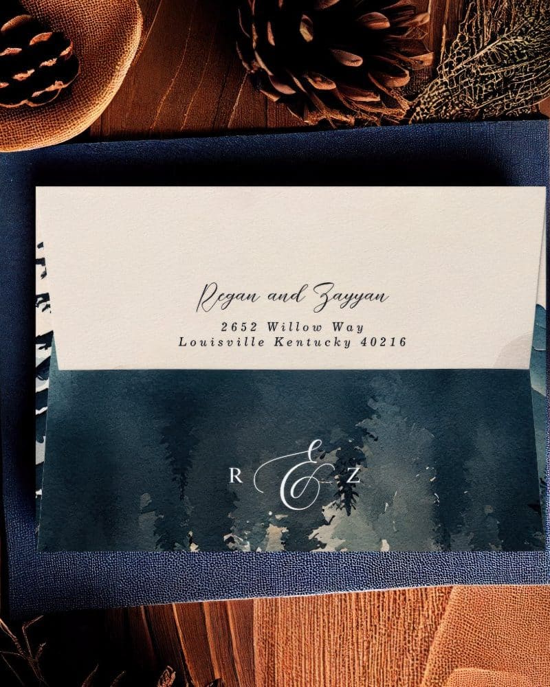 Wedding invitation with a watercolor forest design and the names Regan and Zayyan, their address, and monogram.