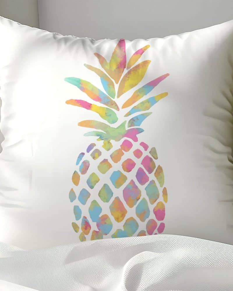 White pillow with a pastel watercolor pineapple design.