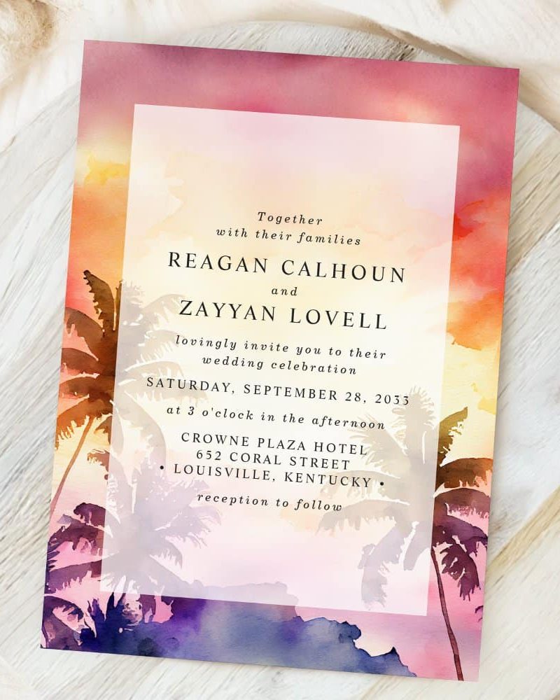 Wedding invitation with a watercolor sunset and palm trees.