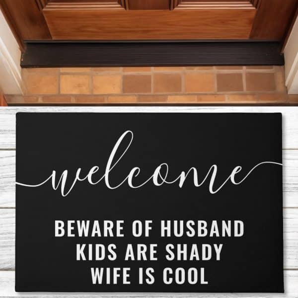 Black Welcome Mat With White Script Lettering That Says Welcome, Beware Of Husband, Kids Are Shady, Wife Is Cool.