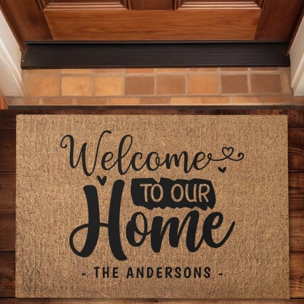 A Tan Welcome Mat With Black Lettering That Reads Welcome To Our Home, The Andersons.