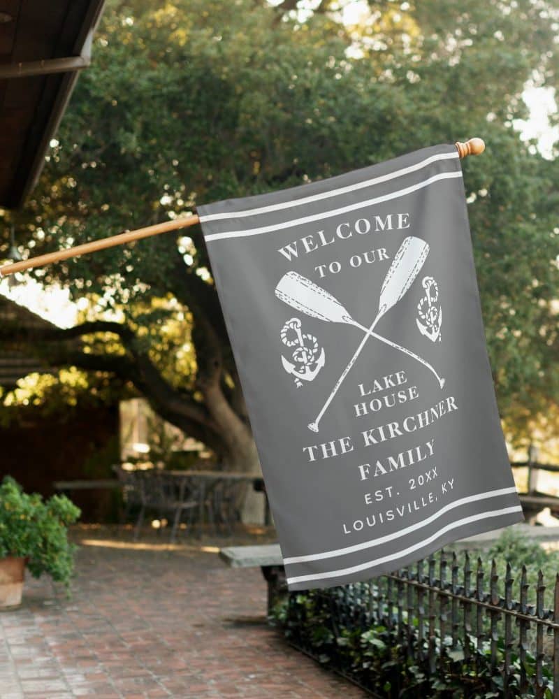 A gray welcome flag with white lettering and crossed oars.