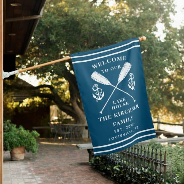 A Navy Blue Welcome Flag With Crossed Oars, Anchors, And The Kirchners Family Name.