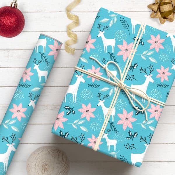 A Light Blue Gift Wrapped With A Pattern Of White Reindeer And Pink Poinsettias.