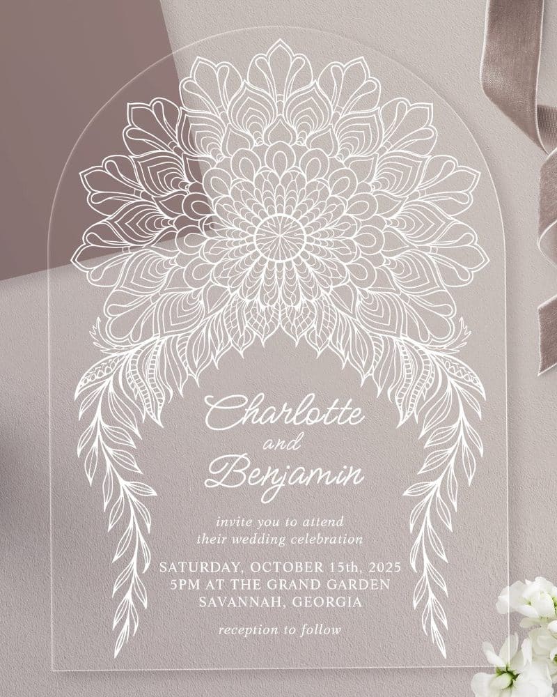 Arch-shaped clear acrylic wedding invitation with white mandala and floral designs, announcing Charlotte and Benjamin's wedding.