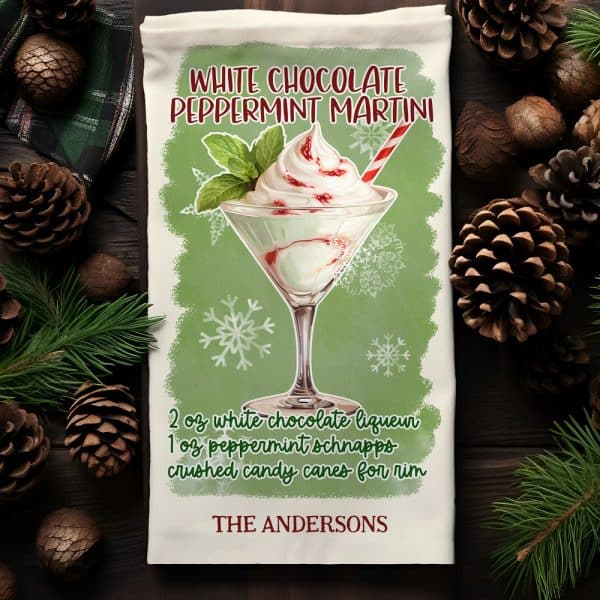 A Kitchen Towel Depicting A White Chocolate Peppermint Martini Garnished With Whipped Cream And A Candy Cane.