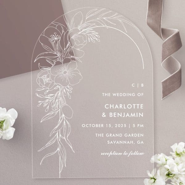Clear Acrylic Wedding Invitation With White Floral Design And Wedding Details.