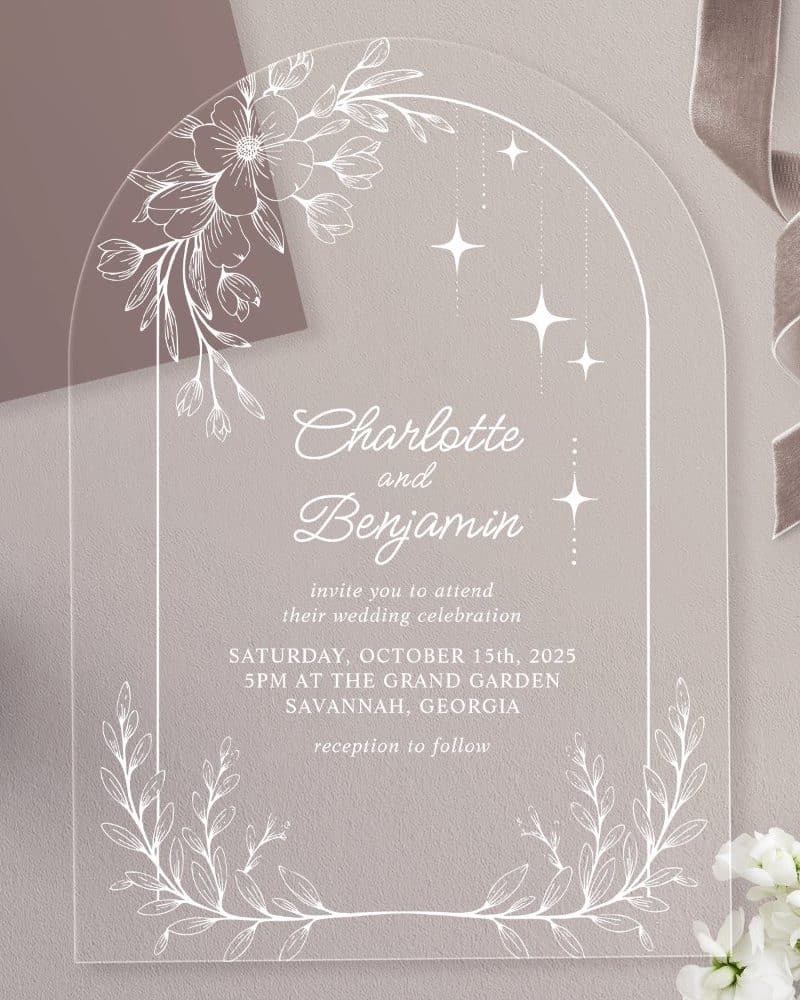 Clear acrylic wedding invitation with floral and star accents, announcing Charlotte and Benjamin's wedding.