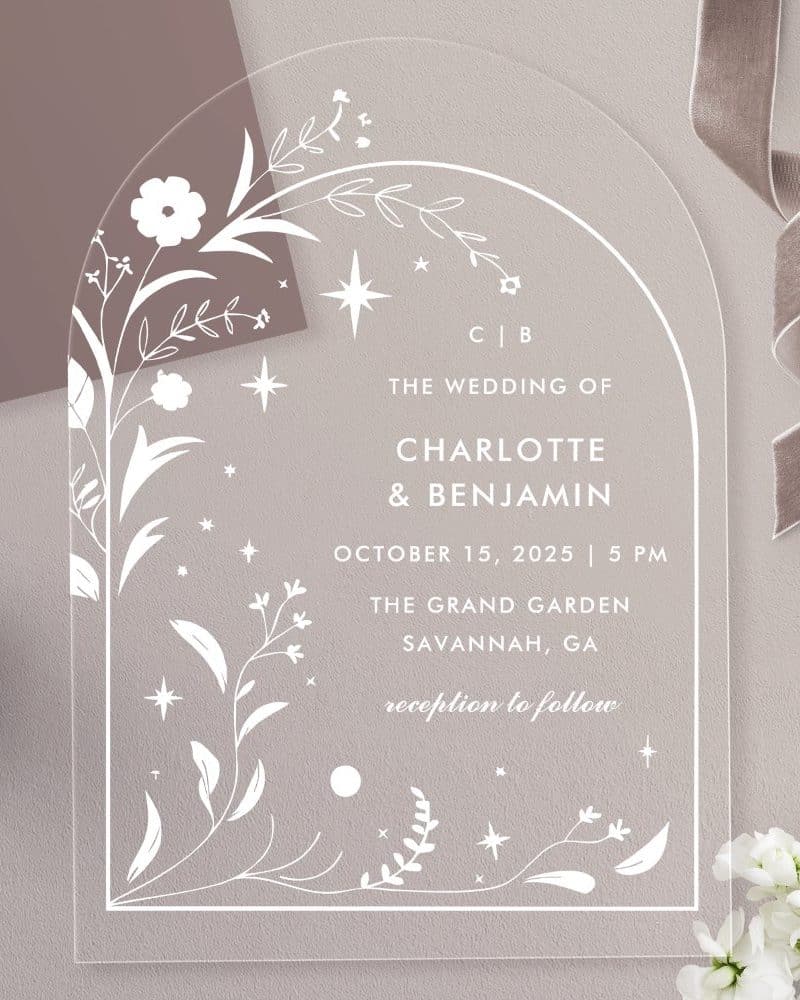 Clear arch-shaped wedding invitation with floral and star details, announcing Charlotte and Benjamin's wedding.