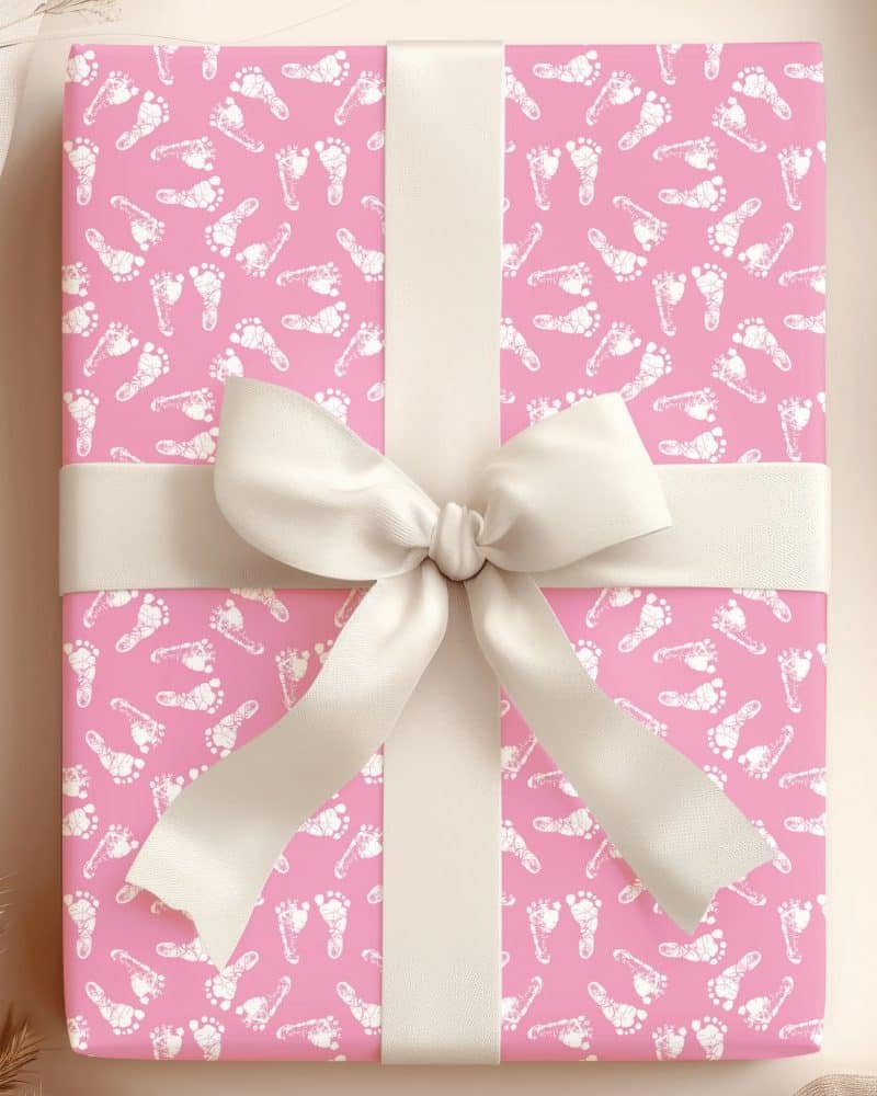 Pink gift wrapped with a cream-colored ribbon and a baby footprint pattern.