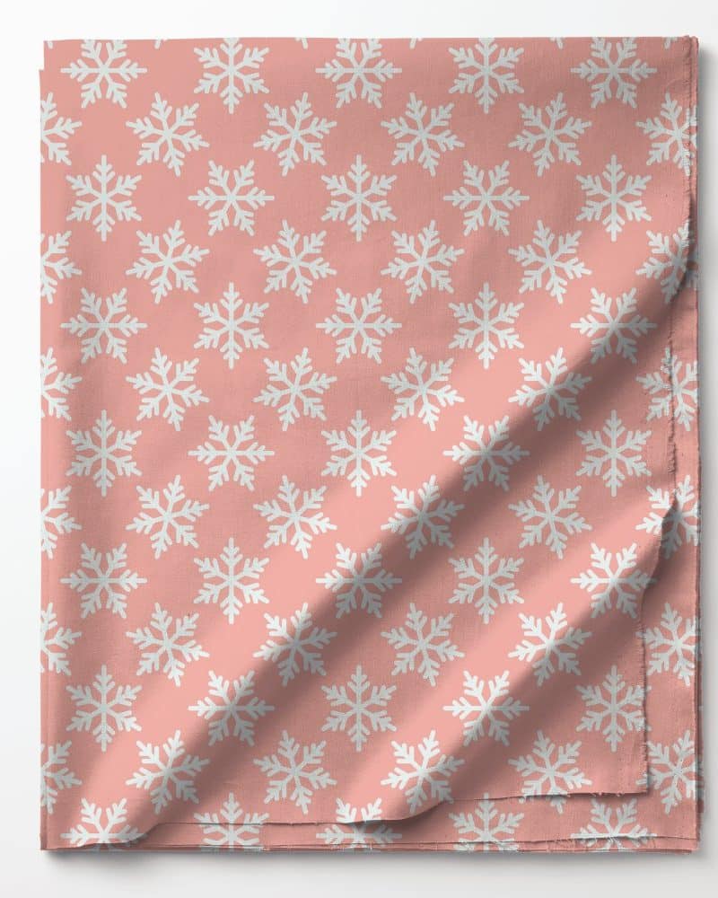 Pink fabric with a repeating pattern of white snowflakes.