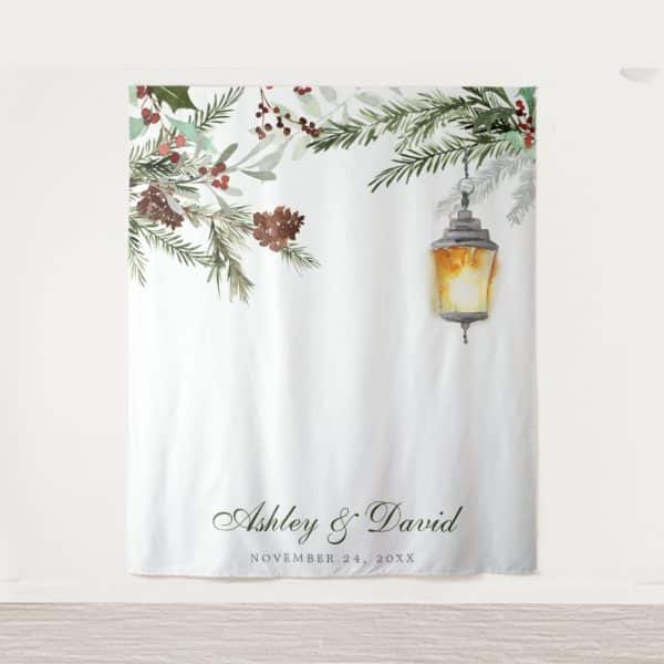 White Wedding Backdrop With Watercolor Greenery, Pine Cones, And A Lantern; Ashley &Amp; David'S Names And Wedding Date Are At The Bottom.