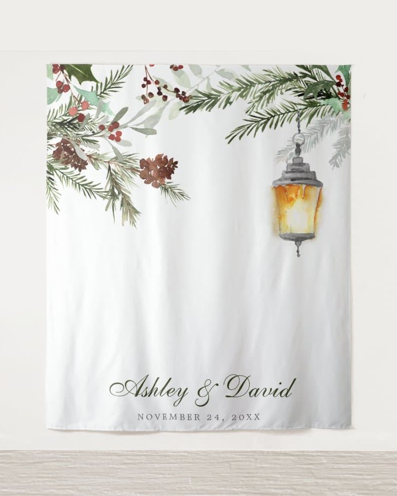 White wedding backdrop with watercolor greenery, pine cones, and a lantern; Ashley & David's names and wedding date are at the bottom.