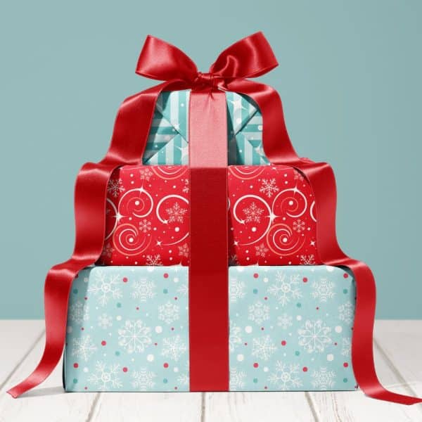 Stack Of Three Christmas Presents Tied With A Large Red Ribbon.
