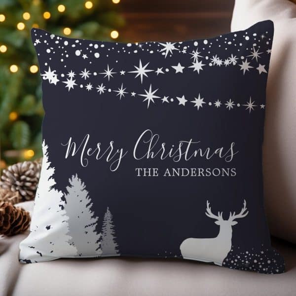Dark Blue Throw Pillow With A Silver Merry Christmas Message, The Andersons Family Name, A Deer Silhouette, And A Snowy Forest Scene.