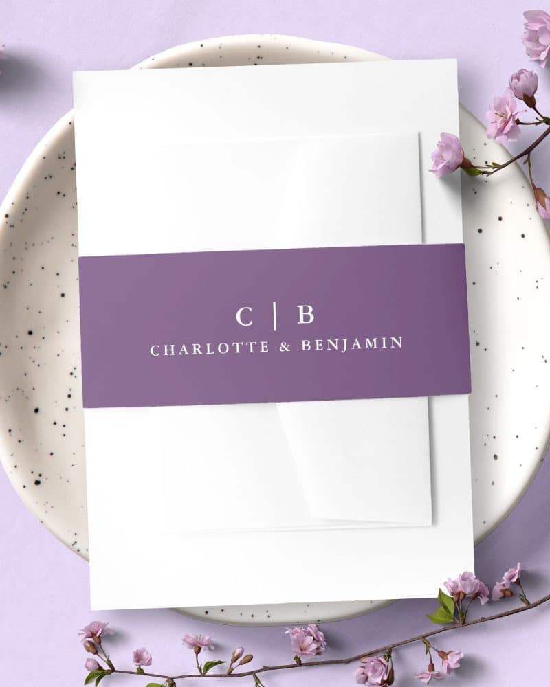 Wedding invitation with a purple band showing the initials CB and the names Charlotte & Benjamin.