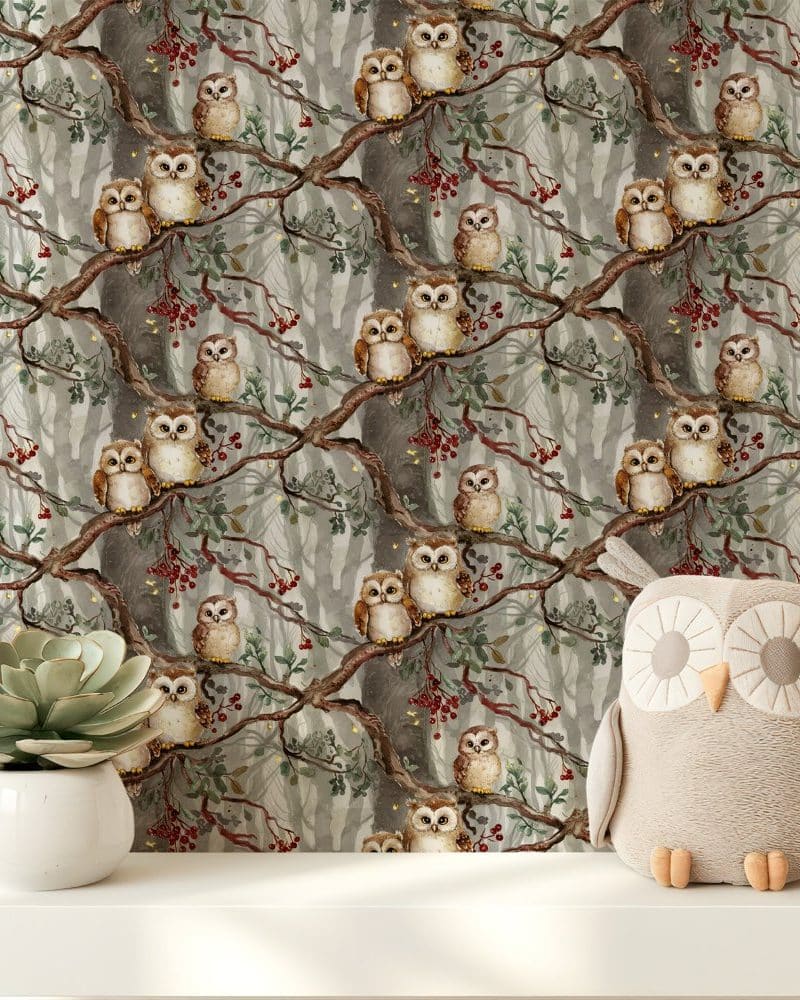 A plush owl sits in front of wallpaper depicting many owls perched on branches in a misty forest.
