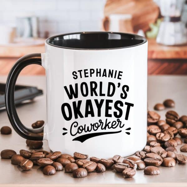 White Coffee Mug With Black Handle And Interior, Displaying The Text Stephanie, World'S Okayest Coworker.