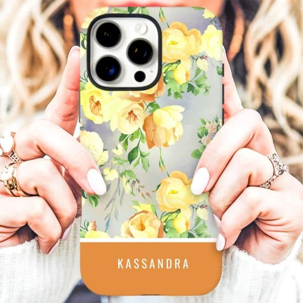 Woman'S Hands Holding An Iphone Case With A Yellow Floral Pattern And The Name Kassandra At The Bottom.