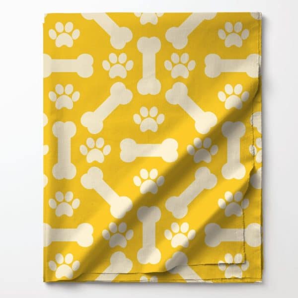 Yellow Fabric With A Pattern Of White Bones And Paw Prints.