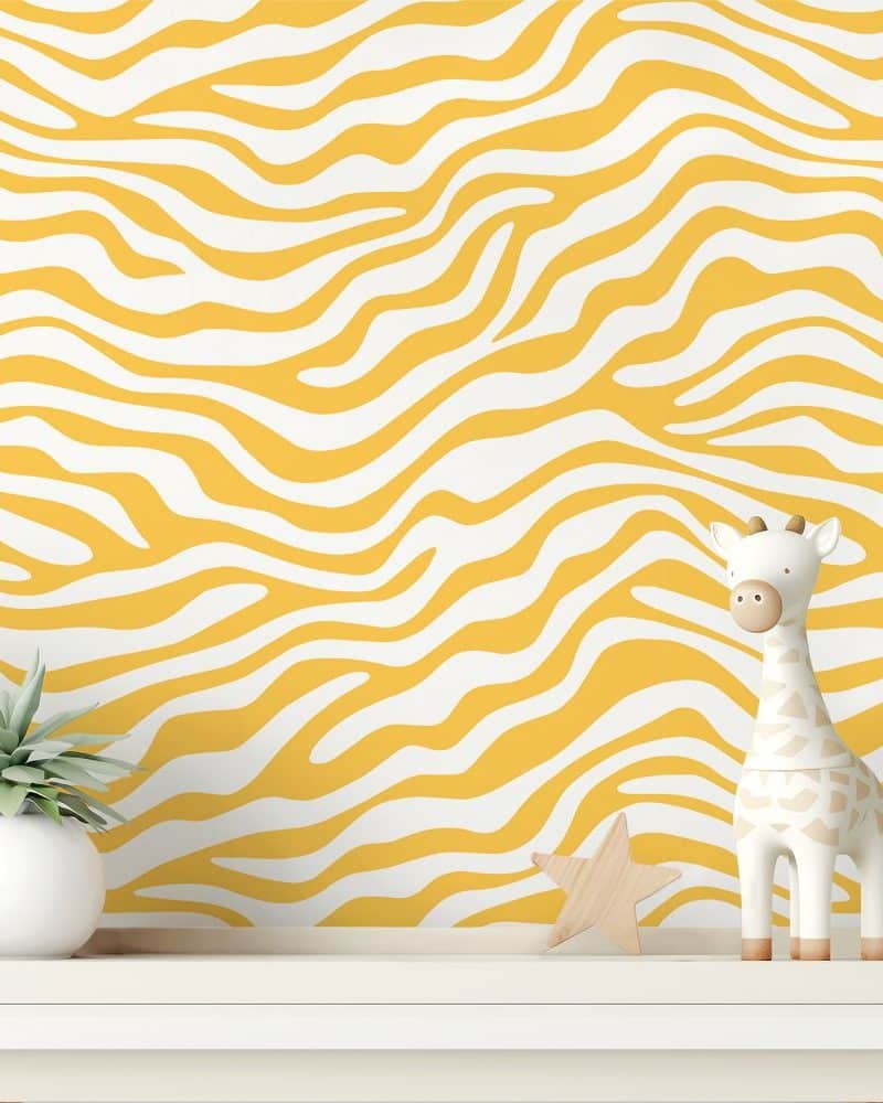 White and yellow zebra striped wall with a small giraffe figurine and a small plant.