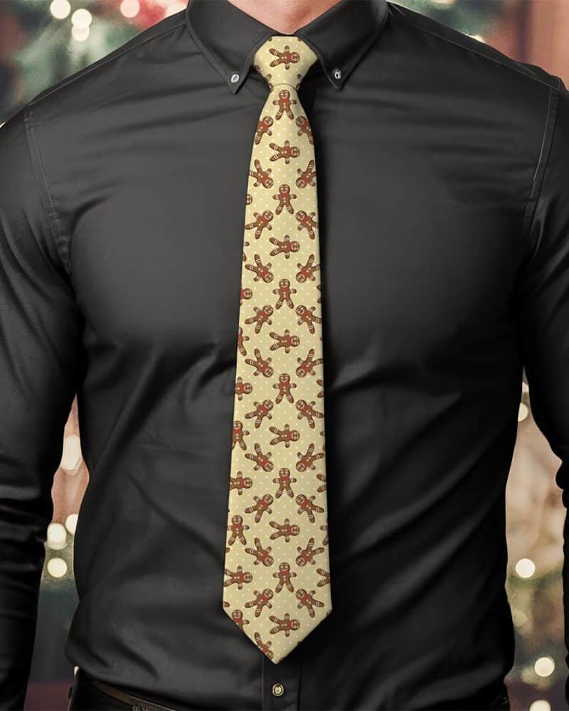 Man wearing a beige tie with a repeating pattern of gingerbread men.