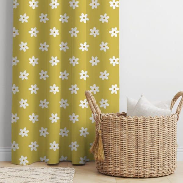 Mustard Yellow Curtain With A Repeating Pattern Of White Daisies, Next To A Wicker Basket Containing Several White Pillows.