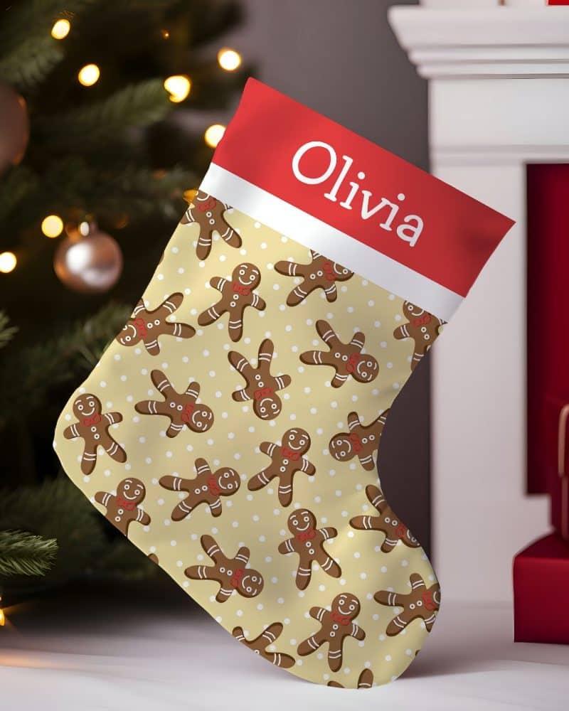 Personalized Christmas stocking with a cream background and repeating gingerbread man pattern, the name Olivia is on the cuff.