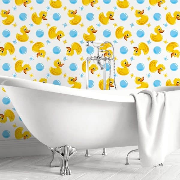 White Clawfoot Bathtub In Front Of Wallpaper Featuring Yellow Rubber Ducks And Blue Bubbles.