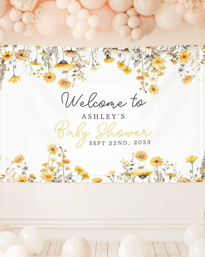 A baby shower banner with yellow wildflowers and text that says Welcome to Ashley's Baby Shower, September 22nd, 2033.