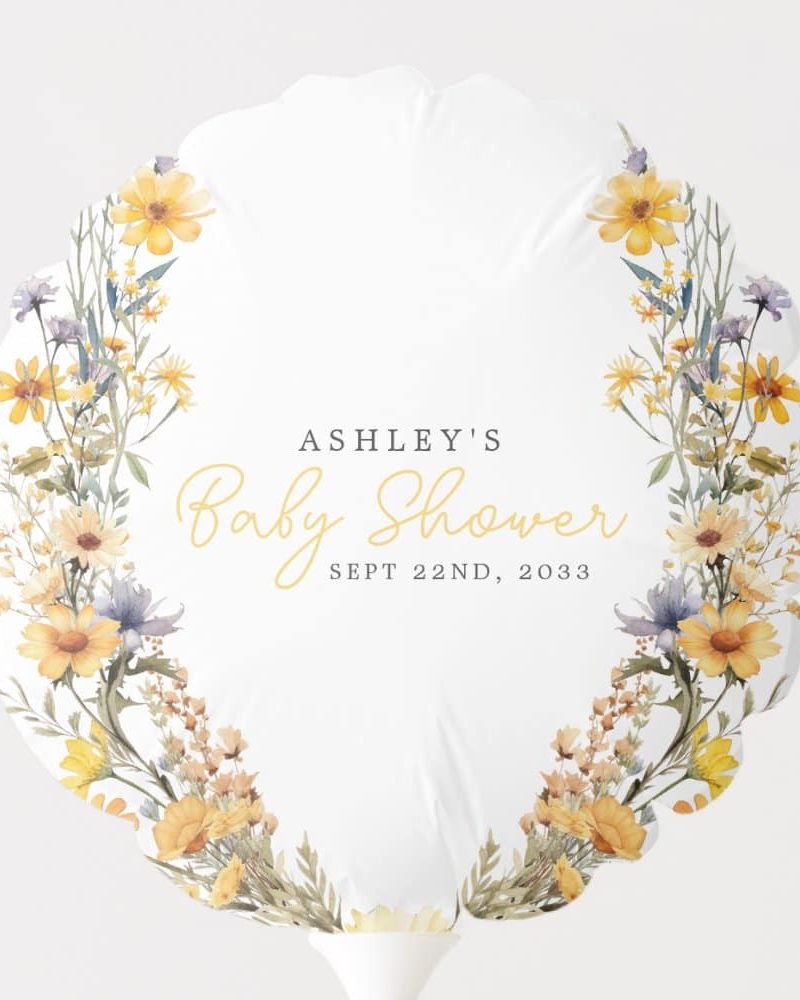 A white balloon shaped like a flower with a watercolor floral border in yellow and blue. The text Ashley's Baby Shower, Sept 22nd, 2033 is in the center.