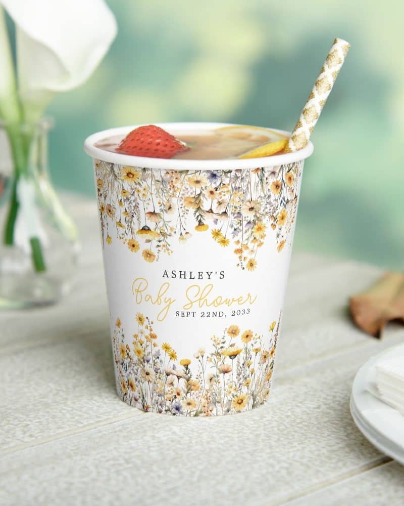 A floral baby shower cup with Ashley's name and date.