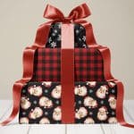 Stack of three Christmas presents tied with a large red ribbon. The wrapping paper features different holiday designs.