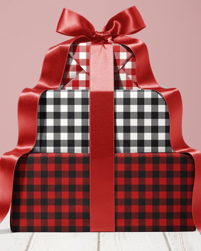 Stack of three gifts wrapped in red and black plaid paper, tied with a large red ribbon.